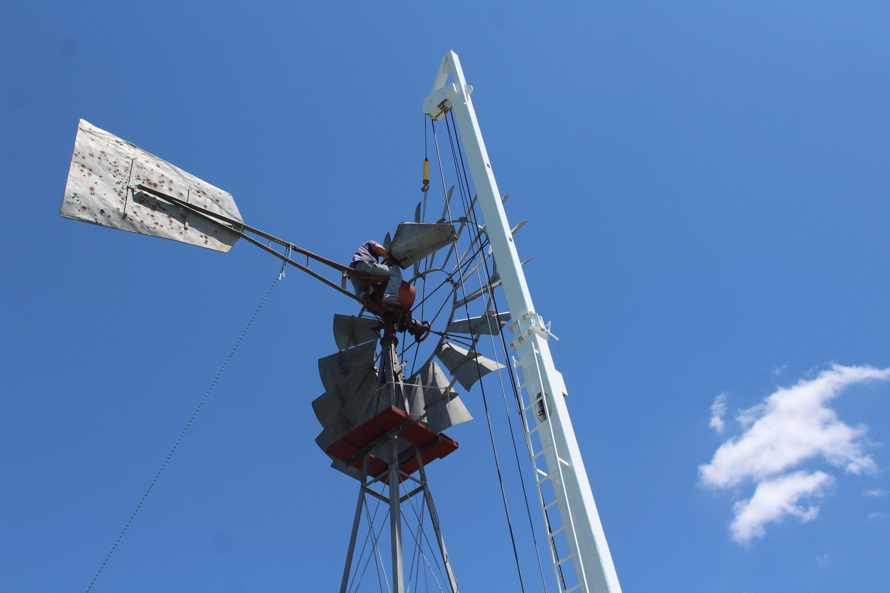 Concho Windmill crew working from a crane on a windmill tower