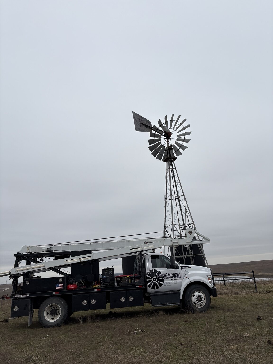 Concho Windmill service truck parked beside a working windmill