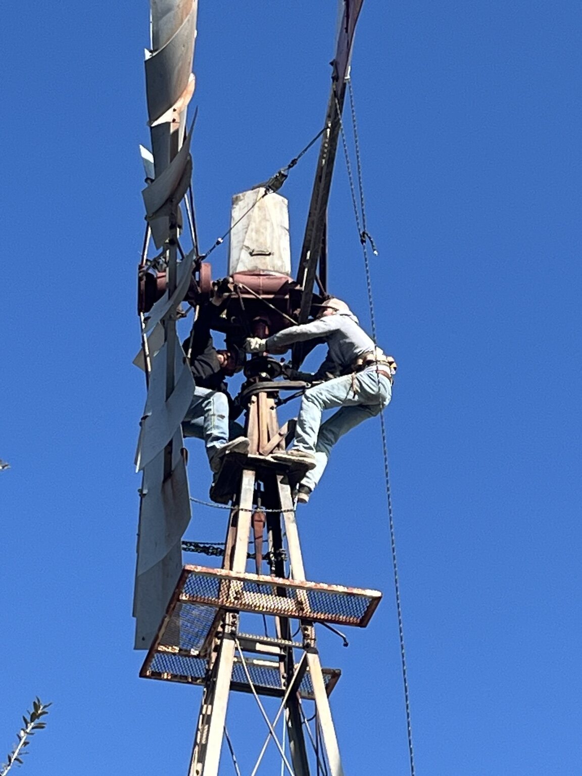 Concho Windmill technician repairing a windmill high on its tower